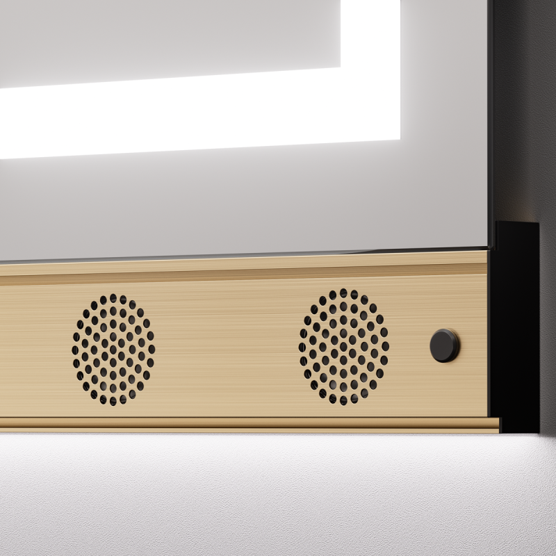 Nahaufnahme des MIRA-Profils in Brushed Gold mit zwei runden Lautsprechergittern unter dem beleuchteten Spiegel